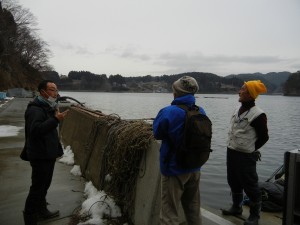 防潮堤の建設計画に頭を悩ませる住民の話を聞く筆者（中央）。気仙沼の大島。（撮影／編集部）