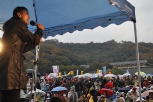 時雨が混じるあいにくの天候だったが帰る人はほとんどいない。左は山本太郎参議院議員。