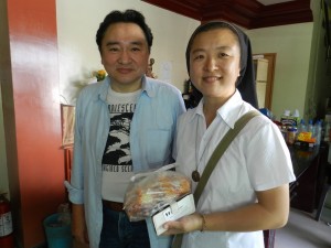 【中】学校に支援物資を届けた菅野さん（左）とシスター・チャン先生。