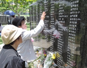 「慰霊の日」で亡き母の名前を探す遺族。糸満市摩文仁の平和祈念公園。（撮影／本誌取材班）