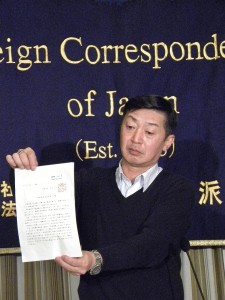 岸田外務大臣の印が押された旅券の「返納命令書」を掲げる杉本さん。（撮影／編集部）