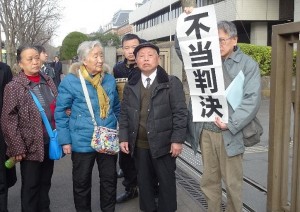 請求棄却に憤る栗遠奎原告団長（右から二人目）ら。２月25日、東京地裁前。（撮影／鈴木賢士）