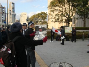 条例反対の街宣に抗議し「レイシズムノー」を掲げる市民。（１月15日、大阪市役所前。撮影／平野次郎）