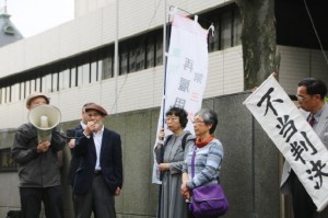 東京地裁前で不当判決に抗議する原告ら。４月18日。（撮影／永尾俊彦）