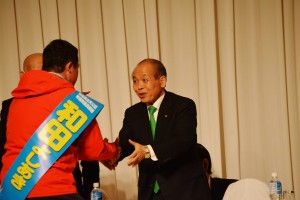 新党大地のセミナーに駆けつけ、登壇する和田よしあき候補と握手する鈴木宗男代表（右）。４月16日、北海道・札幌。（撮影／横田一）