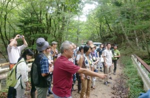 最終処分場候補地の栃木県塩谷町で役場の人（中央）から説明を受ける見学者。９月10日。（写真／みかみめぐる）