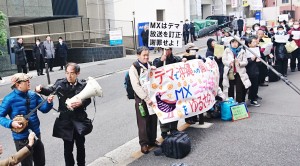 ＴＯＫＹＯ　ＭＸに対する１月19日の抗議行動で唄と三線を披露した豊岡マッシーさん（左）。民謡「安里屋ユンタ」は圧政に対する庶民の抵抗歌としても今に歌い継がれている。（撮影／内原英聡）